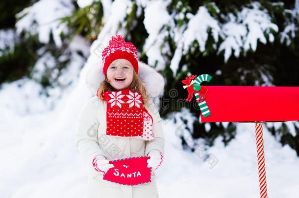 孩子在雪中的圣诞信箱给圣诞老人写信