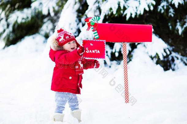 孩子在雪中的圣诞信箱给圣诞老人写信