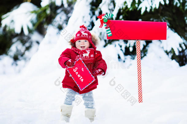 孩子在雪中的圣诞信箱给圣诞老人写信