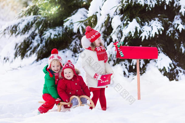 孩子们在雪中的圣诞邮箱给圣诞老人写信