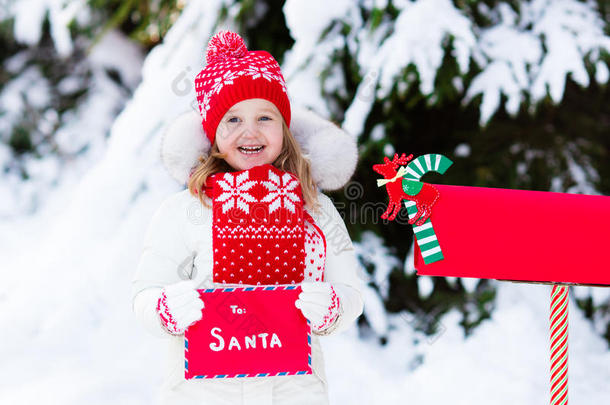 孩子在雪中的圣诞信箱给圣诞老人写信