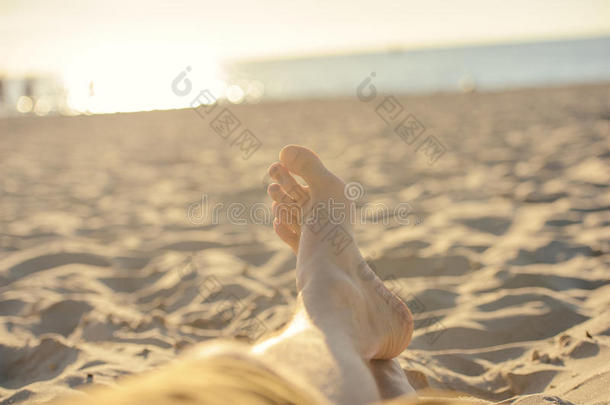 在阳光明媚的夏日，脚在阳光明媚的海滩上特写。