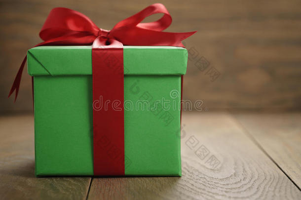 绿色纸<strong>礼<strong>盒</strong></strong>礼品<strong>盒</strong>，盖子和红色丝带蝴蝶结在木桌上，有复制空间
