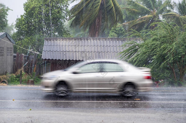 汽车在前面木屋的<strong>大风</strong>雨中行驶
