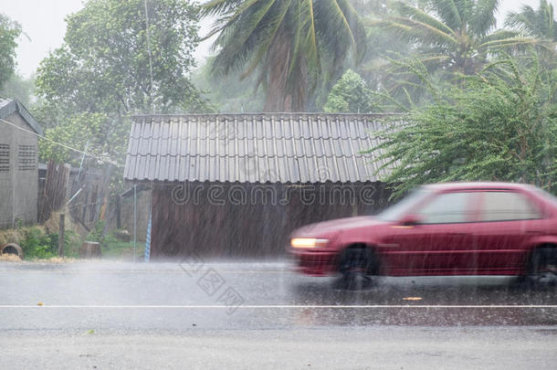 汽车在前面木屋的<strong>大风</strong>雨中行驶