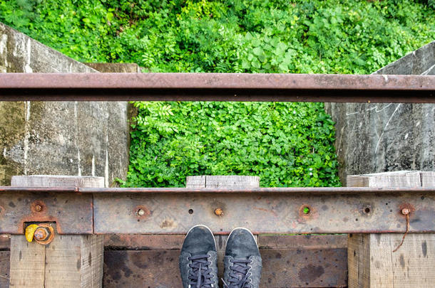 黑色运动鞋在木制的旧铁路上