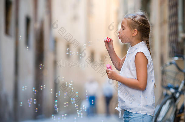 可爱的小女孩在户外吹肥皂泡在欧洲城市。 白种人<strong>孩子</strong>的肖像享受<strong>暑假</strong>
