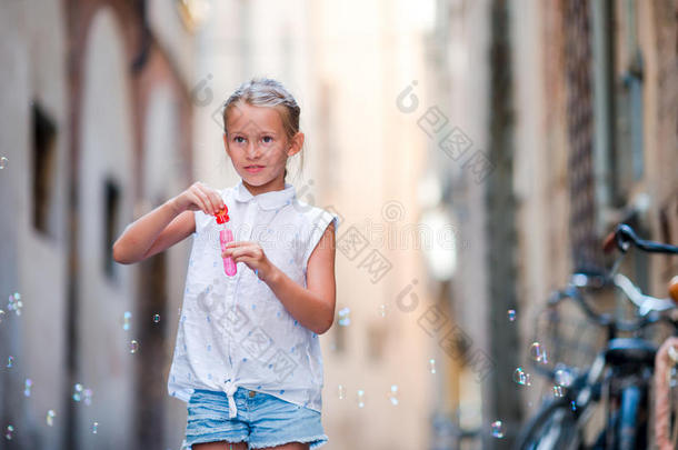 可爱的小女孩在户外吹肥皂泡在欧洲城市。 白种人<strong>孩子</strong>的肖像享受<strong>暑假</strong>