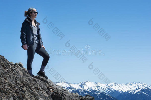 一个活跃的运动女人站在山顶上