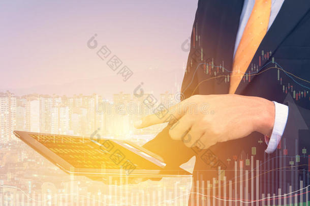 商人交易概念使用平板电脑与金融图形在城市景观背景下，双重曝光风格