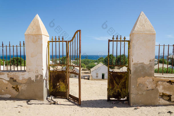 殖民地石墙摇摇欲坠的金属门，俯瞰安哥拉美丽的海洋