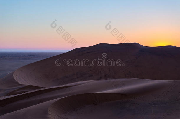 五颜六色的日落在纳米比亚沙漠，纳米比亚，非洲。 风景秀丽的沙丘背光在纳米布诺克洛夫特国家公园