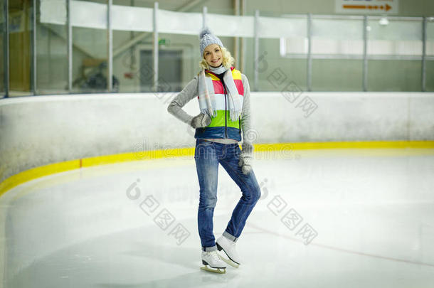 穿着冬天衣服和溜冰鞋在溜冰场上的漂亮女孩