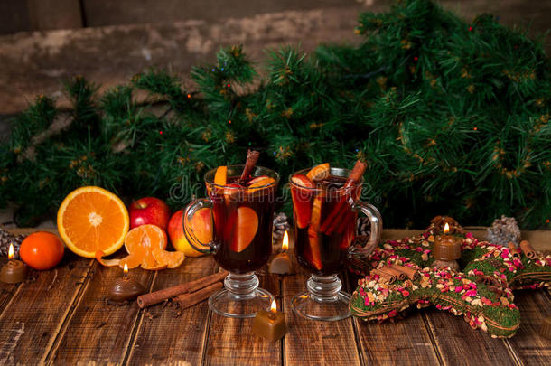 圣诞节在木桌上用水果和香料覆盖葡萄酒。 背景中的圣诞装饰品。 两个眼镜。 <strong>冬季</strong>变<strong>暖</strong>饮料