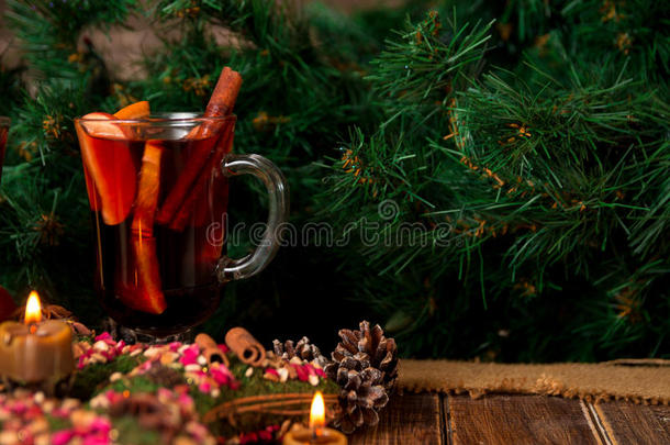 圣诞酒和星星，木桌上的蜡烛。背景中的圣诞装饰。<strong>冬暖</strong>饮料。复制空间。