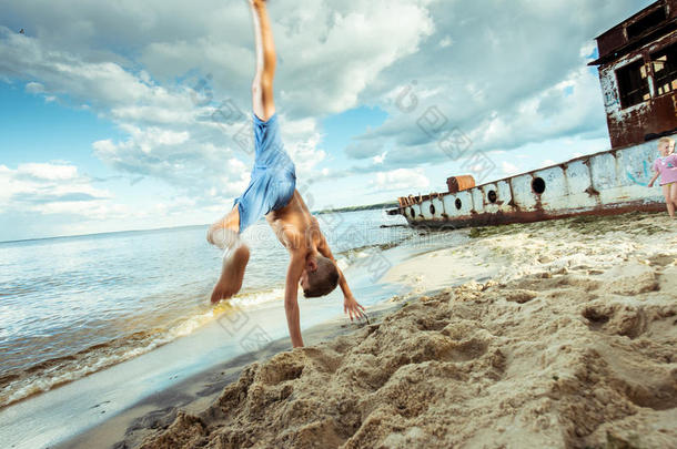 男孩短裤是快乐的跳跃和翻转在海滩上