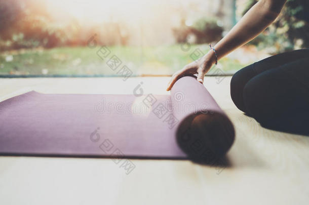 近距离观看华丽的年轻女子在室内练习瑜伽。 漂亮的女孩为练习课准备垫子
