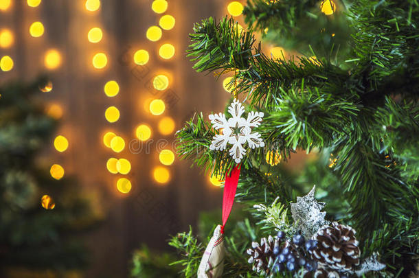 用圣诞玩具和黄色灯光装饰的绿色圣诞树和花环。