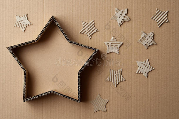 圣诞礼物盒的形状是一颗星星，周围是装饰品，在纸板背景上