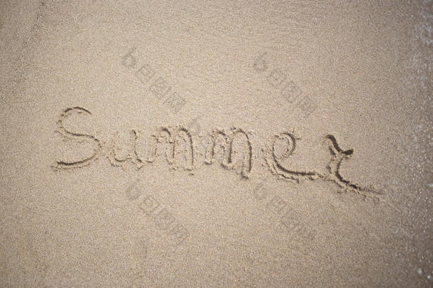 手在沙滩上做文字，写着夏日的阳光和大海