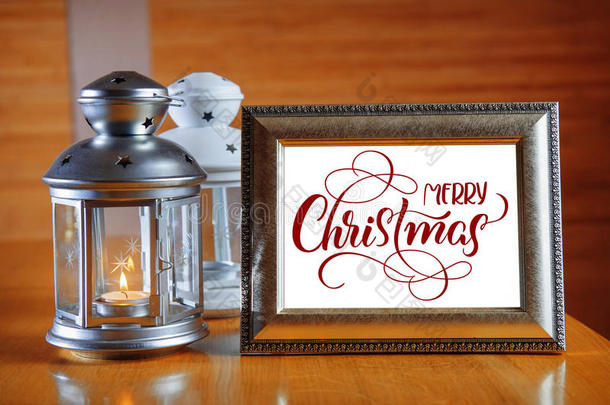 木桌上的框架上有文字圣诞快乐。 书法刻字