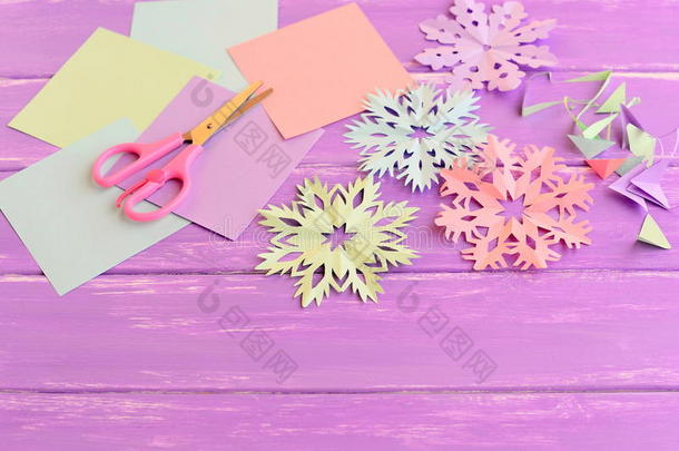彩色纸雪花，彩色纸和废料，剪刀在丁香木背景