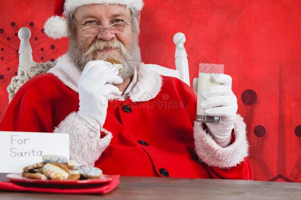 圣诞老人<strong>一桌</strong>拿着一杯牛奶和饼干的复合图像
