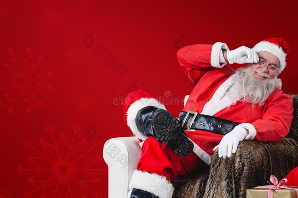 圣诞老人坐在沙发上，旁边放着一袋圣诞礼物的综合形象