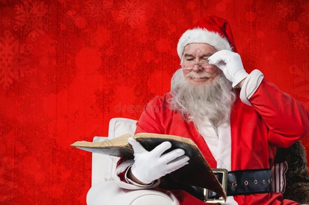 圣诞<strong>老人</strong>在<strong>扶</strong>手椅上阅读圣经的复合图像