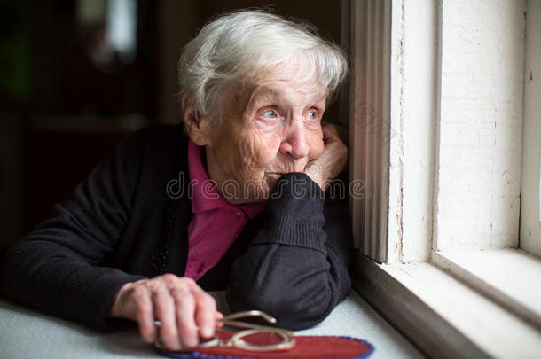 一个女人悲伤地看着窗外。