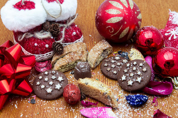 圣诞节的静物用生姜蜂蜜饼干，装饰品，松树，鞋子，礼物，花环巧克力糖果在木制背景上