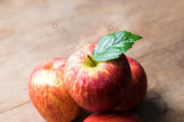 一组红苹果放在木桌上，红苹果背景为好