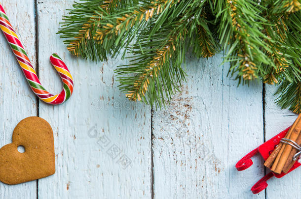 圣诞树深色，饼干和棒棒糖在白色木板上。