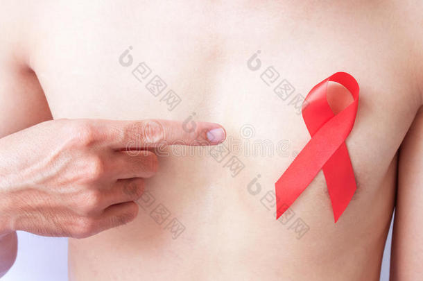 手指针手指到红色丝带在胸部为艾滋病意识公司