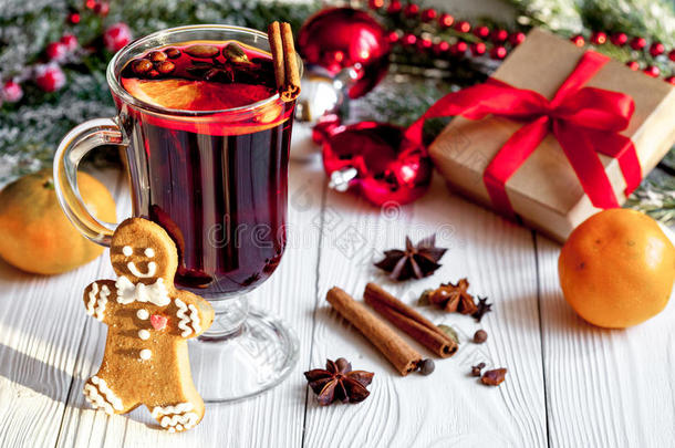 圣诞节在木制背景上用杯子里的香料覆盖葡萄酒