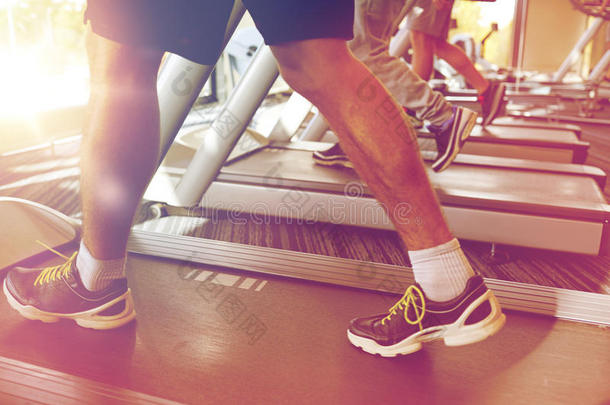 关闭男子腿在跑步机上行走在健身房