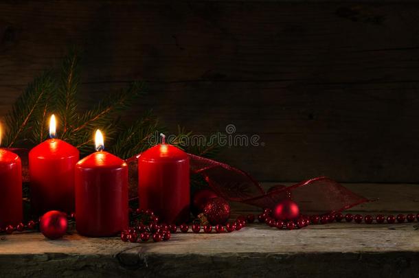 四支红色蜡烛，其中三支在第三次到来时燃烧，圣诞装饰上有云杉树枝和乡村木板上的鲍布