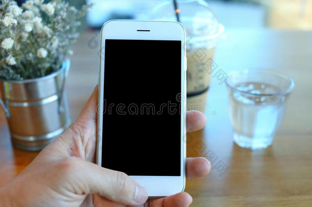 手握智能手机在咖啡咖啡馆