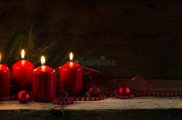 四支红色燃烧的蜡烛为第四次到来，圣诞节装饰与云杉树枝和鲍尔斯在一个乡村板，黑暗的木制