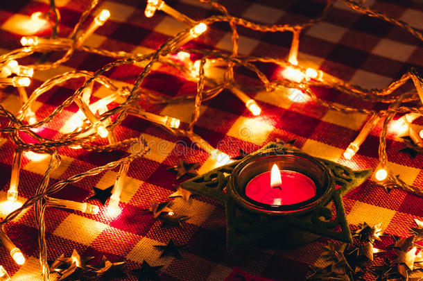 蜡烛和花环在格子桌布的背景下