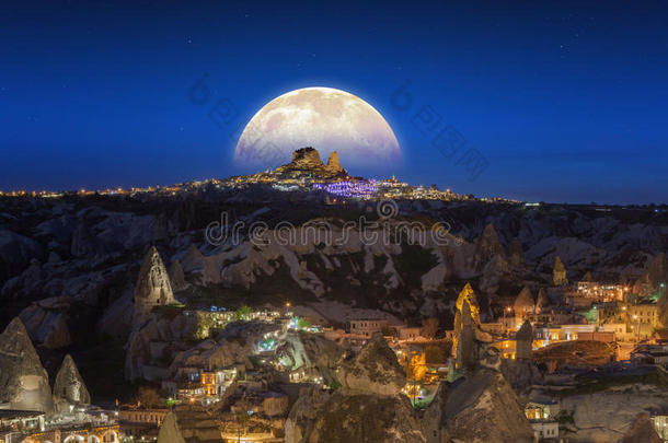 满月升起在土耳其卡帕多西亚的乌希萨尔城堡之上