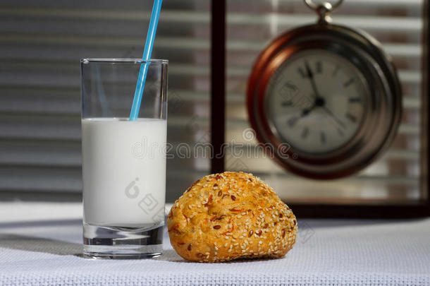 一杯牛奶，面包和手表在<strong>桌子</strong>上。 <strong>早餐</strong>。