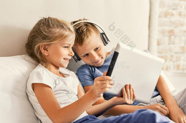 可爱的哥哥和妹妹在家享受平板电脑