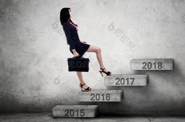 女商人走上楼梯走向2017年的数字
