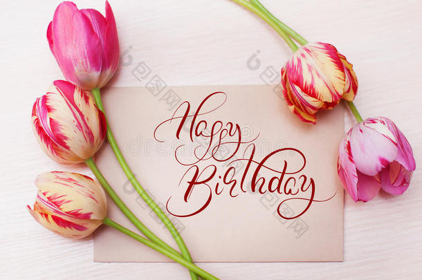 白色背景上的红色郁金香花束，文字生日快乐。 书法刻字