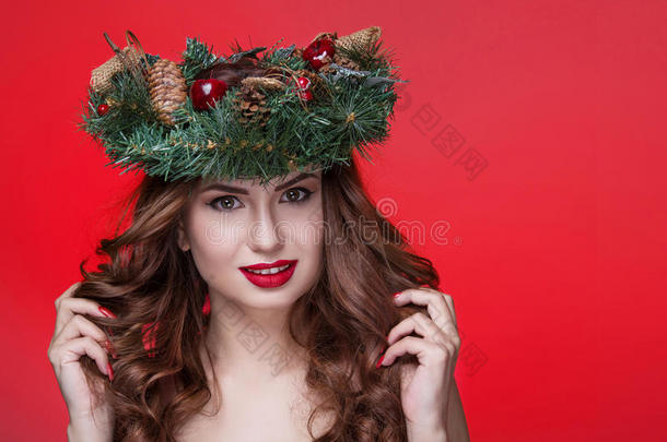 圣诞节或<strong>新年美女</strong>肖像孤立在红色背景上。 美丽的女人，奢华的妆容和圣诞花环