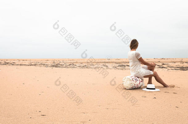 女孩坐在海边的一个钓鱼浮标上。