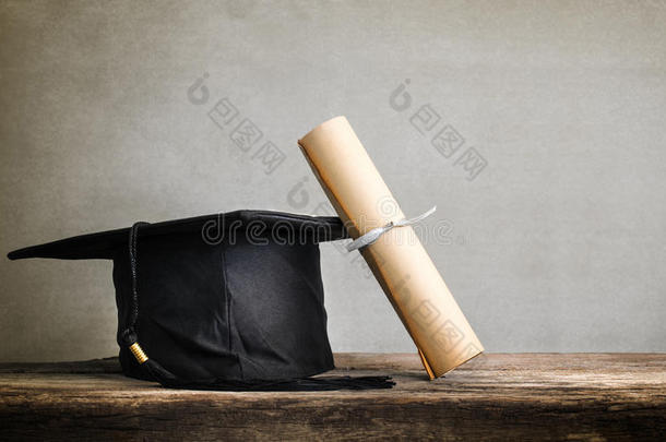 毕业帽，帽子带学位纸在木桌上空着准备