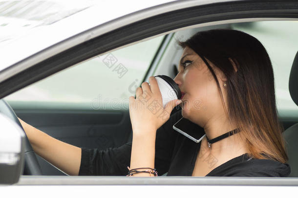 特写年轻女子坐在车里拿着咖啡杯喝酒，从外面的<strong>司机</strong>窗口看到，女<strong>司机</strong>