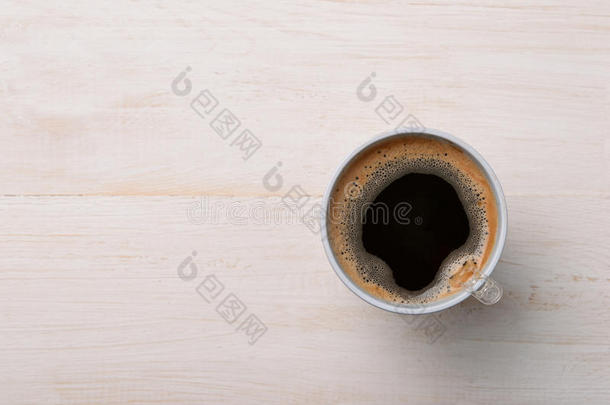 白色木制桌子上的塑料杯中的黑色咖啡